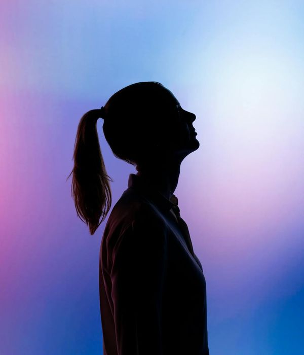 Silhouette of a person in a calm, balanced pose against a soft background.